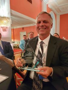 Leo Lantz Smiling as he holds up the Remodeler of the Year award
